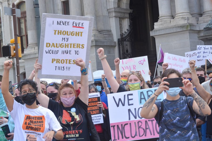 Protesters raise their fists in solidarity, promising to fight for women’s rights, especially the right to choose if they need to have an abortion.